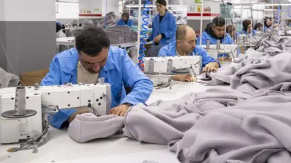 Machinist intensely focused on assembling a thick, heavy-weight garment.