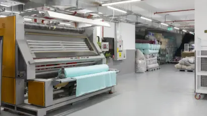 Wide view of an industrial fabric inspection and rolling machine in the Istanbul Factory warehouse.