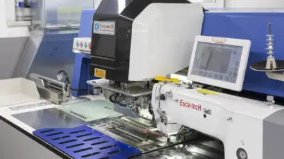 Close-up of the digital touchscreen interface on a modern automated sewing Esca-tech machine.