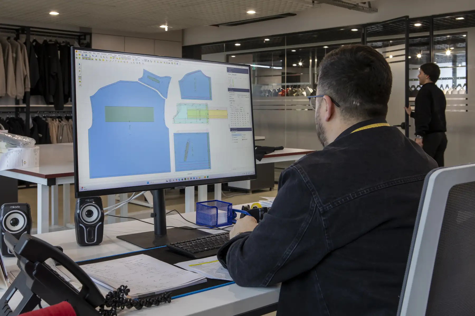 Fashion designer working on garment sketches and tech packs inside a premium Istanbul atelier.